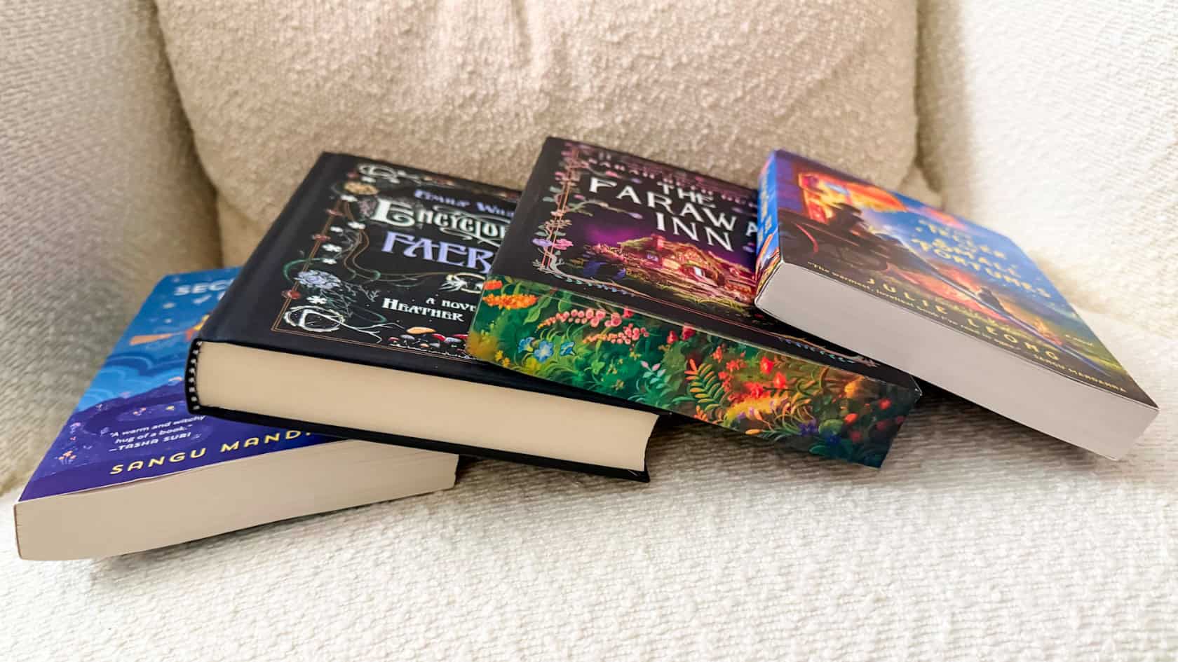 A set of cozy fantasy books for homebodies and cottagecore readers in my reading chair
