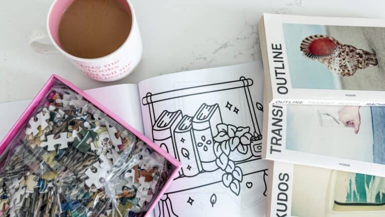 my soft week menu cozy setup with my coffee, jigsaw puzzle, coloring pages, and the outline trilogy books