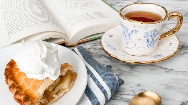 Cozy at-home solo date setup with books, apple pie, tea, and blankets
