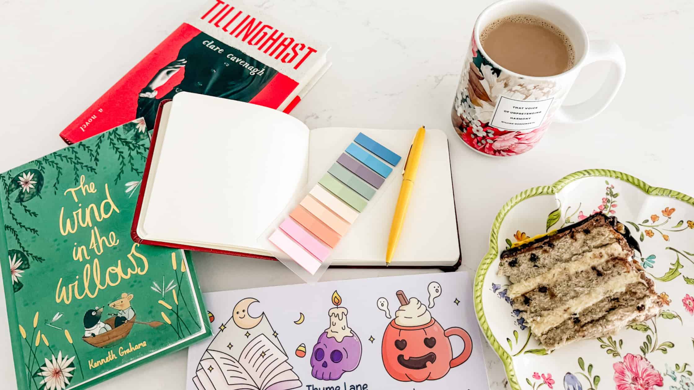 my soft week menu flatlay featuring books, my journal, bookish halloween coloring, coffee and cake