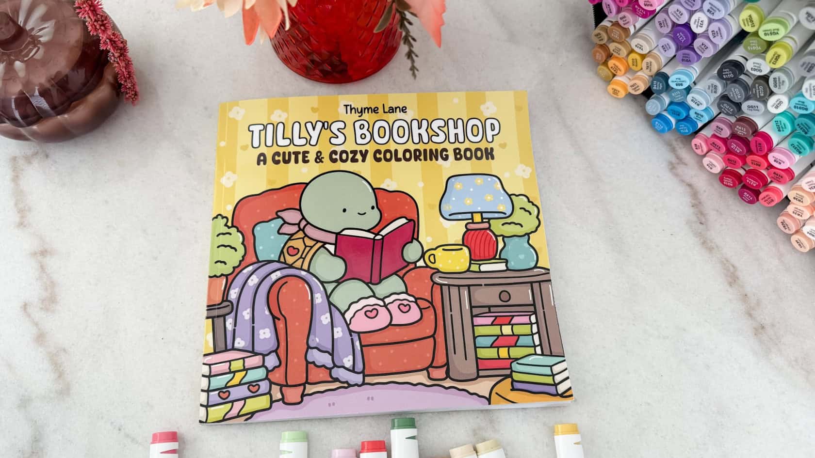 Cozy coloring book featuring Tilly's Bookshop coloring book featuring Tilly the Turtle and her cozy bookshop flatlay with my markers